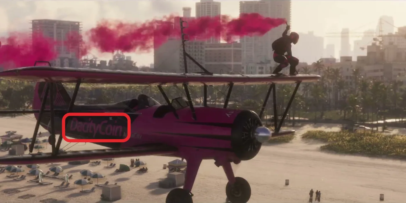 Frame at 0:56 of the Grand Theft Auto VI Launch Trailer: a pink stunt biplane with a wing walker and pink smoke over a beach, “DacityCoin” on its fuselage boxed in red.